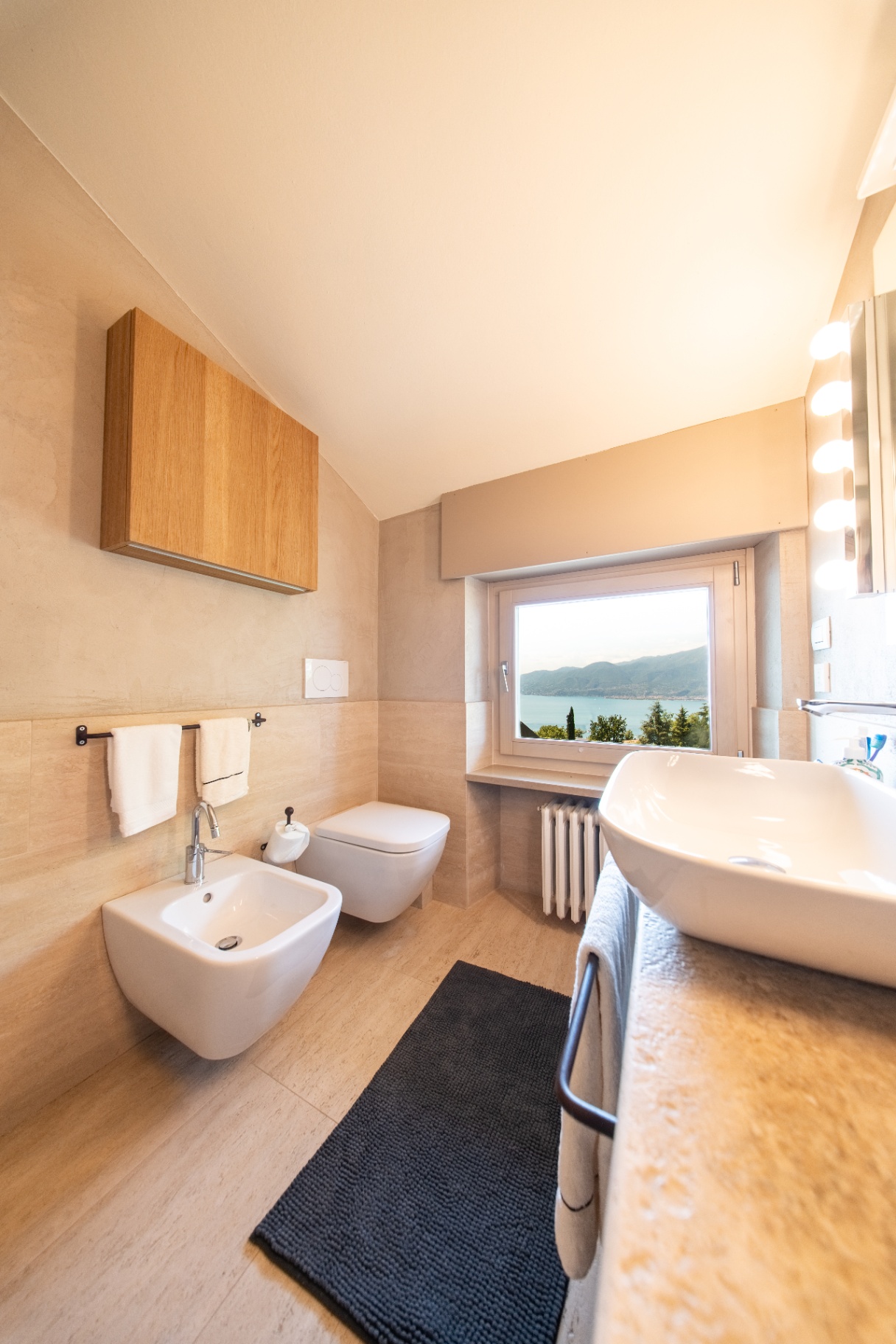 Ensuite bathroom in travertine with lake and mountain view