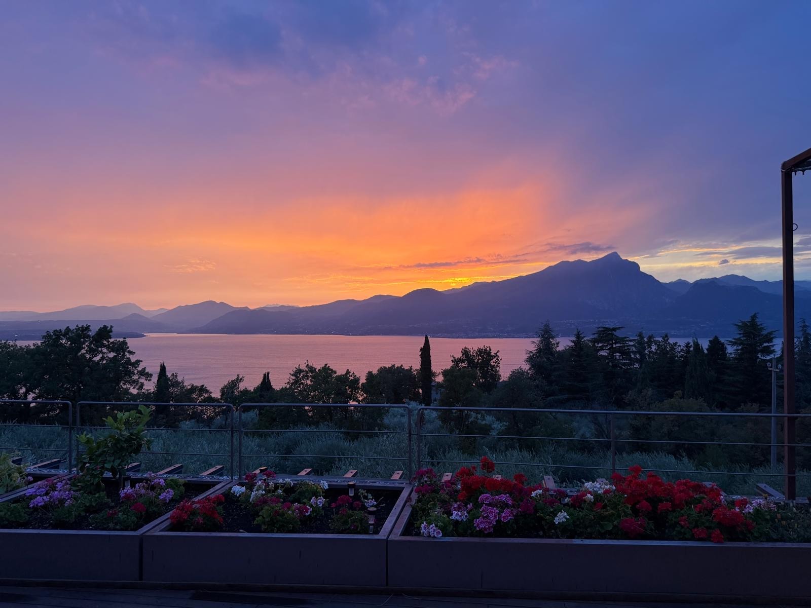 Sunset over Lake Garda from the villa's terrace with flower planters