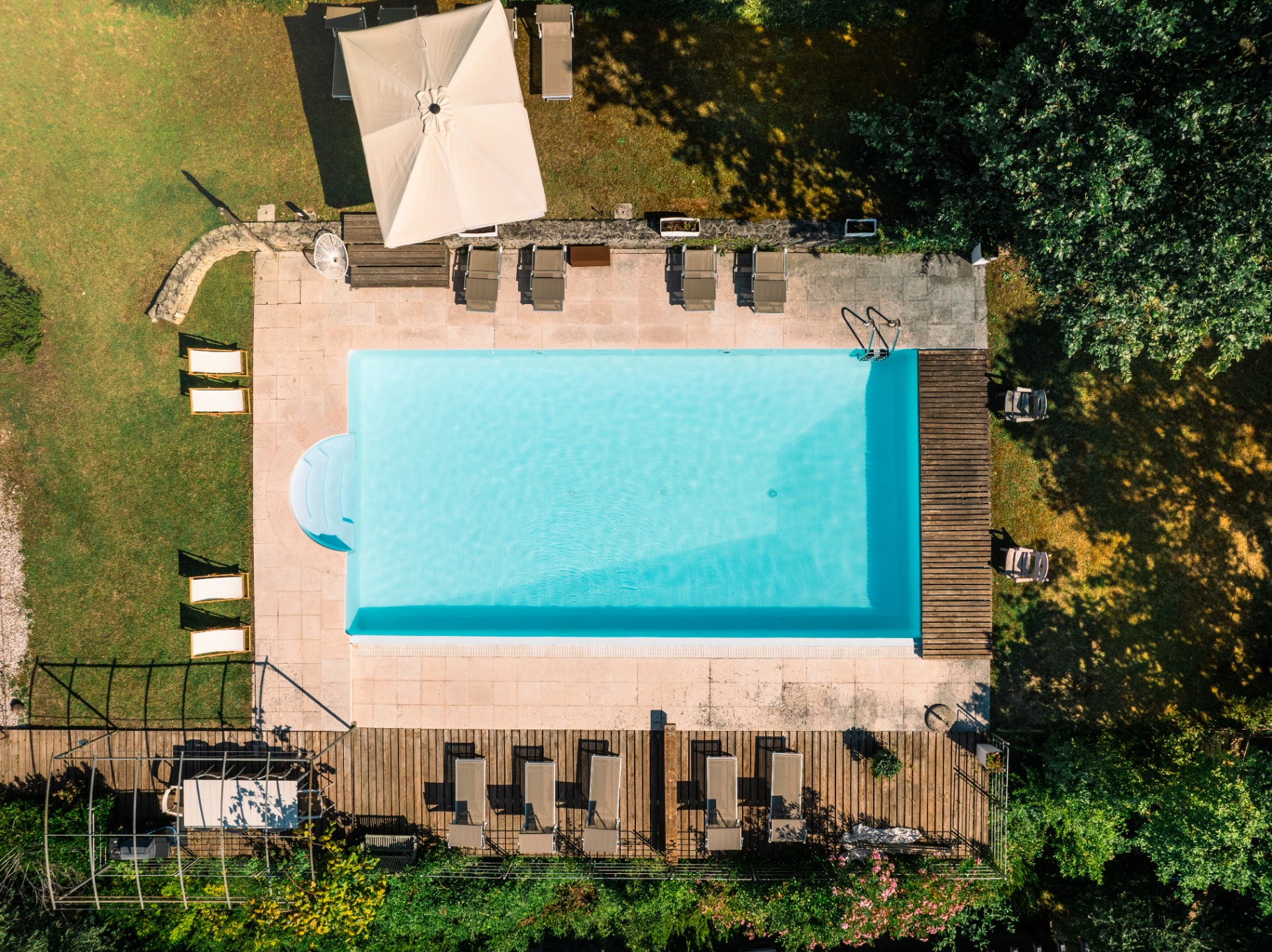 Top-down view of the pool, loungers and parasol