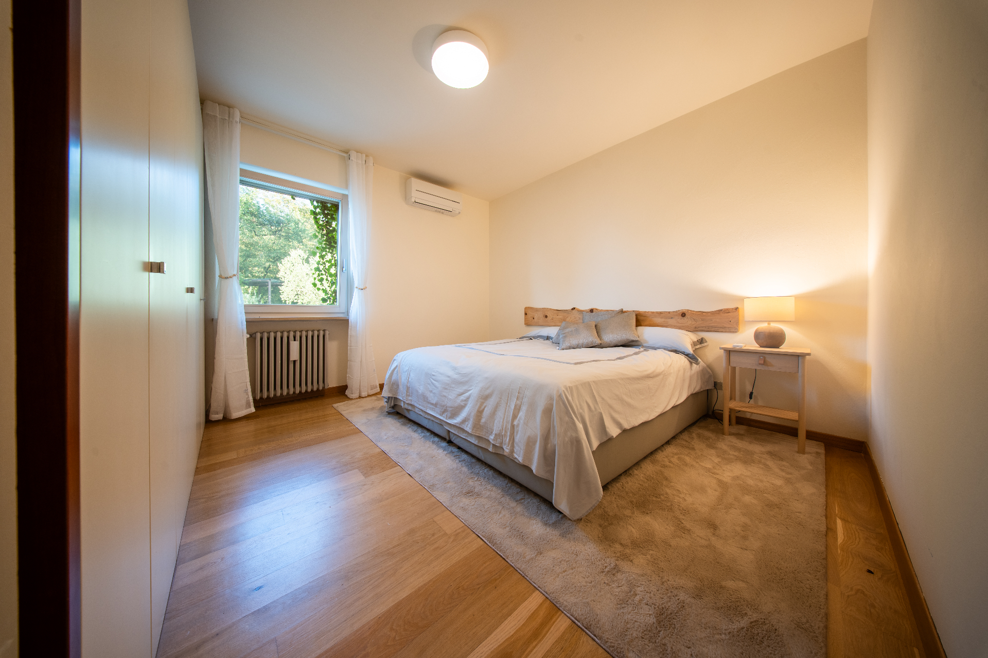 Warm-lit double bedroom with wooden floors