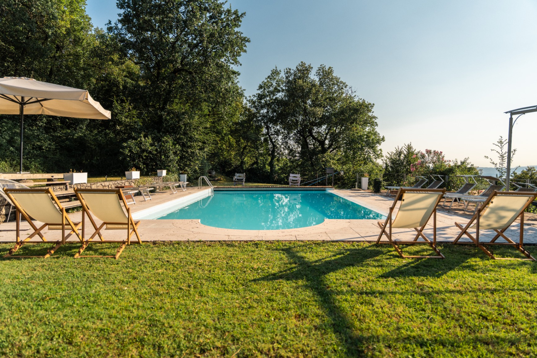 Pool with sun loungers and deckchairs on the lawn